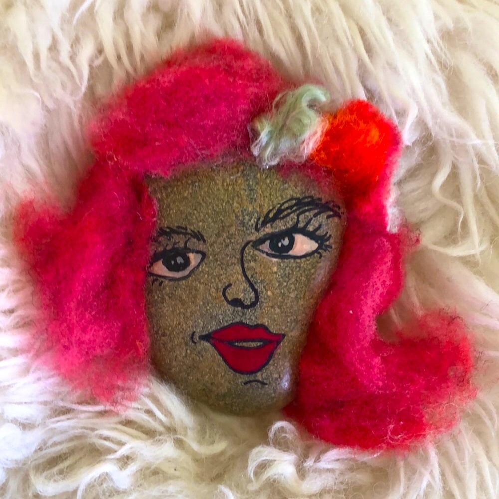 Faces painted on rock, wool hair, wax coating